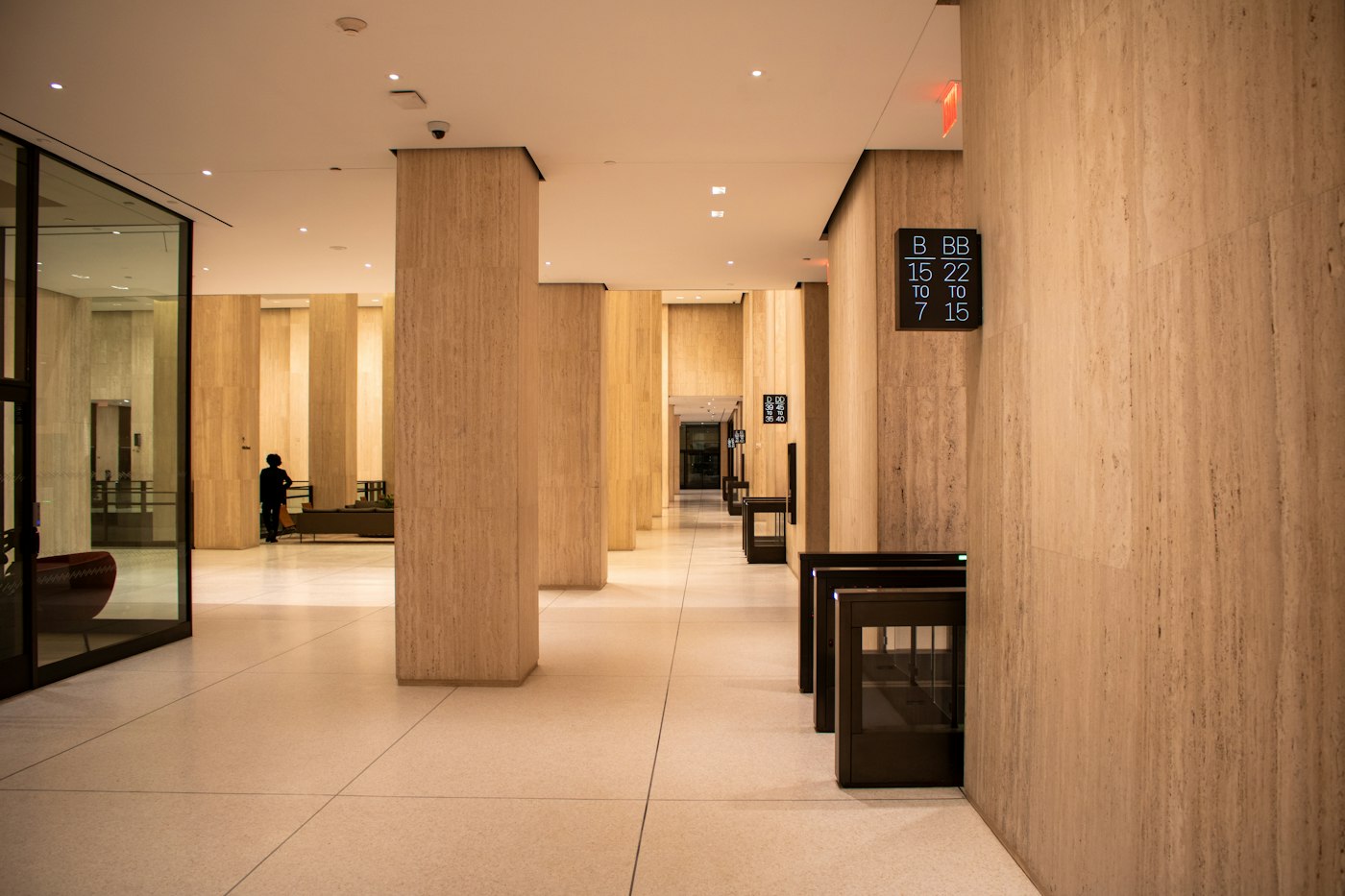 A commercial building lobby with stone columns and security gates